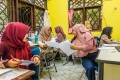 Mitarbeiterinnen der größten Mikrofinanzinstitution in Indonesien Mitra Bisnis Keluarga (MBK) besprechen sich in ihrem Büro. MBK bietet Gruppenkredite für Frauen an. Die Oikocredit-Partnerorganisation hat die Richtlinien der Smart Campaign unterzeichnet, um Überschuldung zu verhindern.